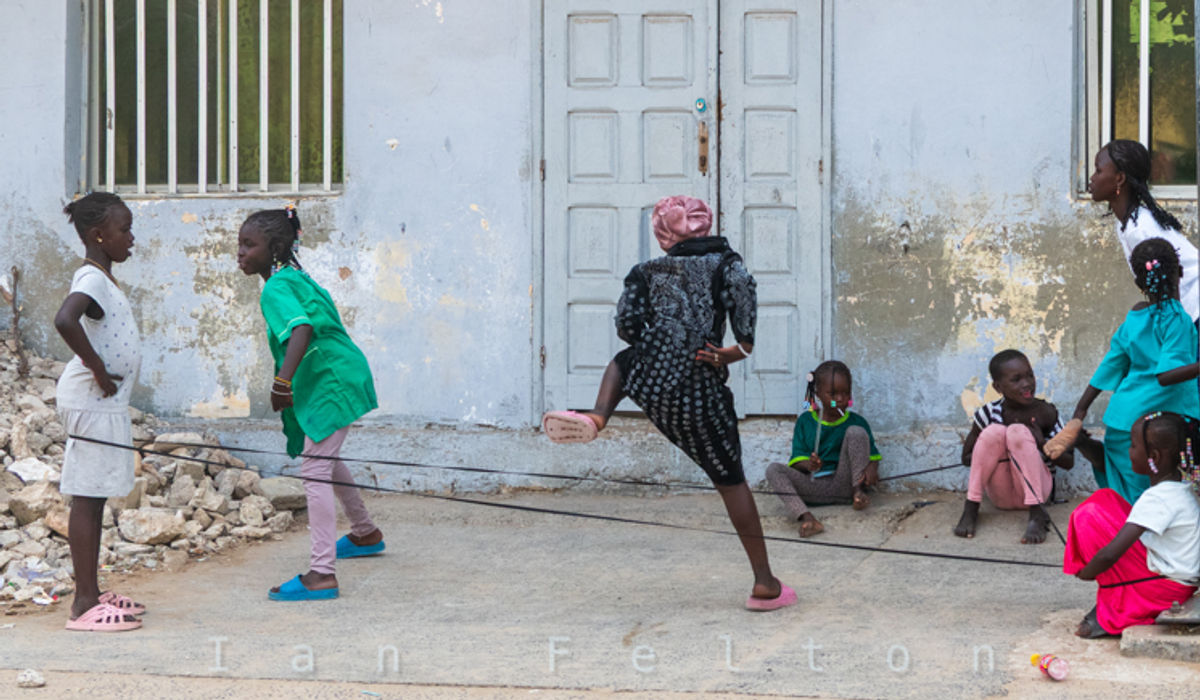 A bunch of girls playing a rope jumping game