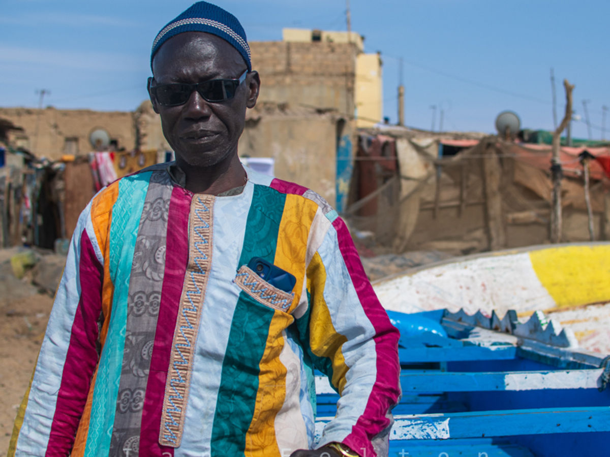 Cheikh posing beside a fishing boat